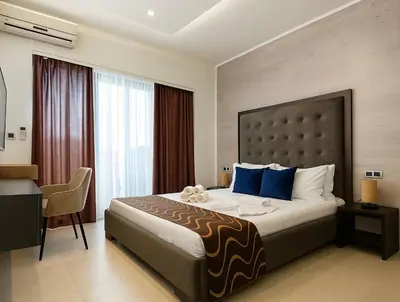a hotel room with a large bed and a desk at Hotel RESIDENCE in Ulcinj