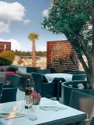 a table with plates and wine glasses on a patio at Hotel RESIDENCE in Ulcinj