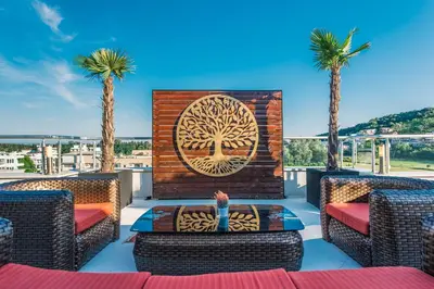a patio with palm trees and a wall with a tree mural at Hotel RESIDENCE in Ulcinj