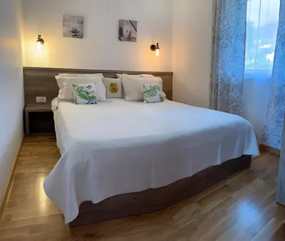 a bedroom with a large bed with white sheets and pillows at Ive Lole Ribara 38 in Becici