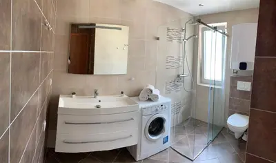 a bathroom with a washing machine and a sink at Ive Lole Ribara 38 in Becici