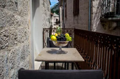 a bowl of fruit sitting on a table on a balcony at Boutique Hotel Hippocampus in Kotor