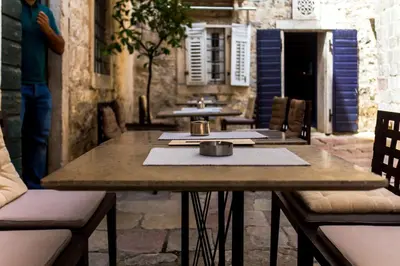 a wooden table with two tables and two chairs at Boutique Hotel Hippocampus in Kotor