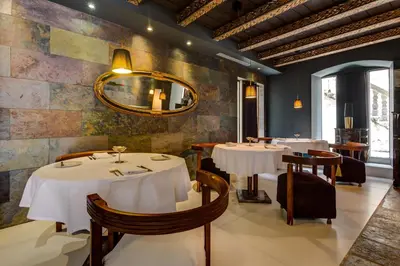 a restaurant with white tables and chairs and a mirror at Boutique Hotel Hippocampus in Kotor