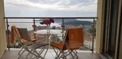 a table and chairs on a balcony with a view at The Magic Sea View Apartments in Budva