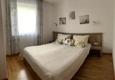 a bedroom with a white bed with pillows and a window at The Magic Sea View Apartments in Budva