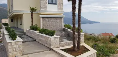 a building with palm trees next to the ocean at The Magic Sea View Apartments in Budva