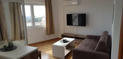 a living room with a couch and a tv at The Magic Sea View Apartments in Budva