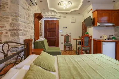 a living room with a bed and a kitchen at Apartments Wine House Old Town in Kotor