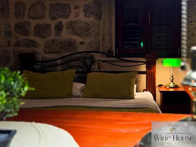 a bed with green pillows and a lamp on a table at Apartments Wine House Old Town in Kotor
