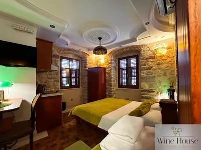 a bedroom with a bed and a desk in a room at Apartments Wine House Old Town in Kotor