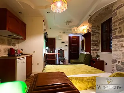 a kitchen and a bedroom with a bed and a table at Apartments Wine House Old Town in Kotor