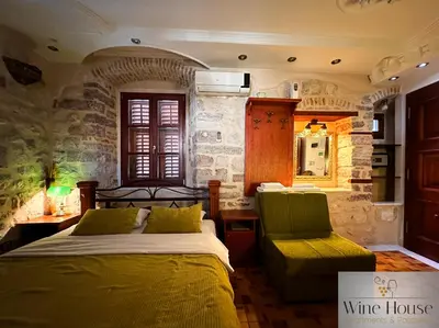 a bedroom with two beds and a table and a chair at Apartments Wine House Old Town in Kotor