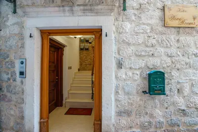 a hallway with a brick wall with a green mailbox at Apartments Wine House Old Town in Kotor