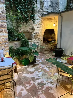a stone patio with a stone fireplace in a yard at Apartments Kotor Old Town in Kotor