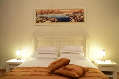 a bedroom with a bed with two lamps and a painting at Apartments Kotor Old Town in Kotor
