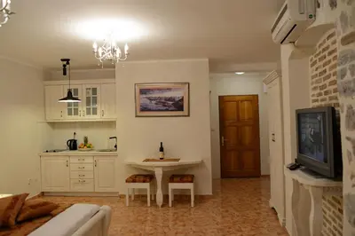 a kitchen with a table and a tv in a room at Apartments Kotor Old Town in Kotor
