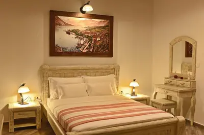 a bedroom with a bed with two tables and a mirror at Apartments Kotor Old Town in Kotor