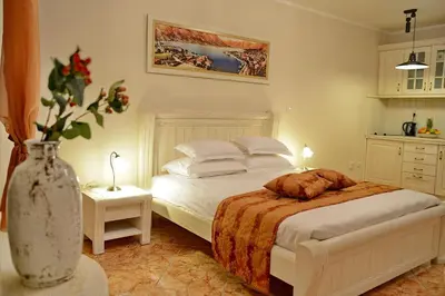 a bedroom with a bed and a vase of flowers at Apartments Kotor Old Town in Kotor