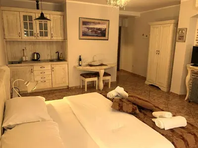 a bedroom with two beds and a kitchen with a table at Apartments Kotor Old Town in Kotor