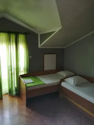 two beds in a room with green curtains at Centar Budva in Budva