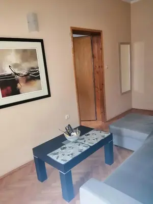 a living room with a blue table and a picture at Centar Budva in Budva