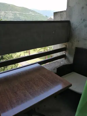 a bench and a chair in a room with a window at Centar Budva in Budva