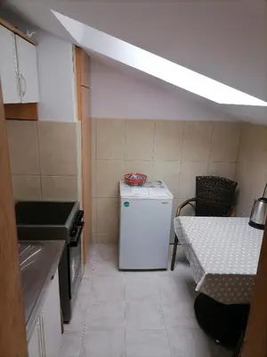 a small kitchen with a white refrigerator and a table at Centar Budva in Budva
