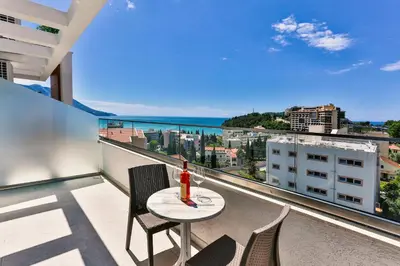 a table and chairs on a balcony with a view of the ocean at Hotel Lusso Mare by Aycon in Budva