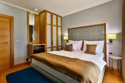 a bedroom with a large bed with a large headboard at Hotel Lusso Mare by Aycon in Budva