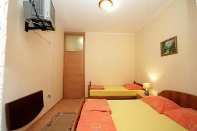 a small room with two beds and a television at Apartments Radosavovic in Bar