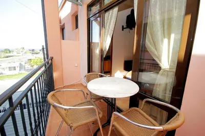 a balcony with a table and chairs and a window at Apartments Radosavovic in Bar
