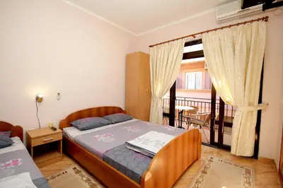 a small bedroom with a bed and a balcony at Apartments Radosavovic in Bar