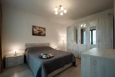 a bedroom with a bed with a tray of food on it at Adria Lux Apartments Sveti Stefan in Budva