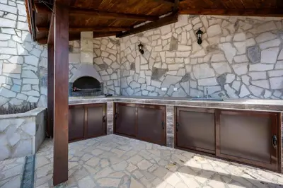 a kitchen with a stone wall and a stove at Adria Lux Apartments Sveti Stefan in Budva
