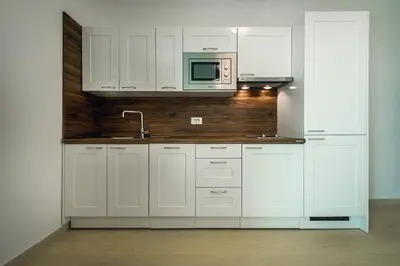 a white kitchen with a sink and a microwave at Adria Lux Apartments Sveti Stefan in Budva