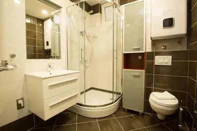 a bathroom with a shower and a toilet and a sink at Apartments Harmonija in Budva