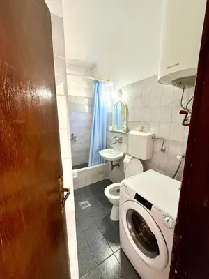 a bathroom with a toilet and a washing machine at Apartments Harmonija in Budva