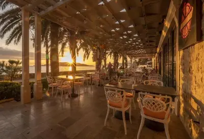 a restaurant with tables and chairs on a patio at Apartments Harmonija in Budva