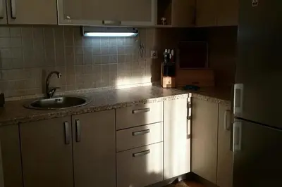 a kitchen with white cabinets and a sink and a refrigerator at Apartments Maljevic Maca in Bar