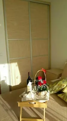 a table with two wine glasses and a basket of flowers at Apartments Maljevic Maca in Bar