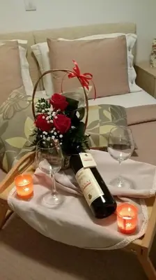 a table with a bottle of wine and two glasses at Apartments Maljevic Maca in Bar