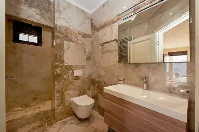 a bathroom with a sink and a toilet and a mirror at Sunbreeze Delux Vilas in Budva