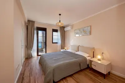 a bedroom with a bed and a night stand with two lamps at Sunbreeze Delux Vilas in Budva