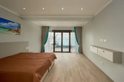 a bedroom with a large bed and a large window at Sunbreeze Delux Vilas in Budva