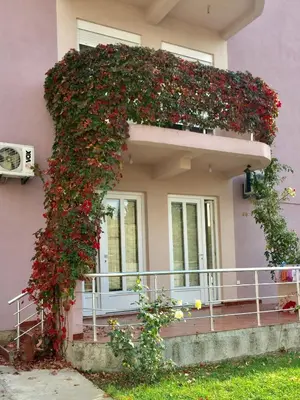 a building with a balcony filled with flowers at Apartmani Milanovic Susanj in Bar