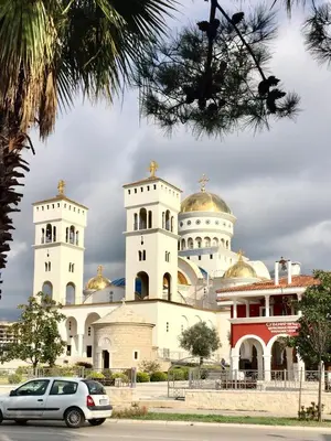 a car parked in front of a church with two towers at Apartmani Milanovic Susanj in Bar