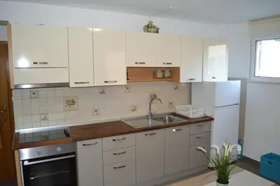 a kitchen with white cabinets and a sink at Vanessa Apartment in Budva