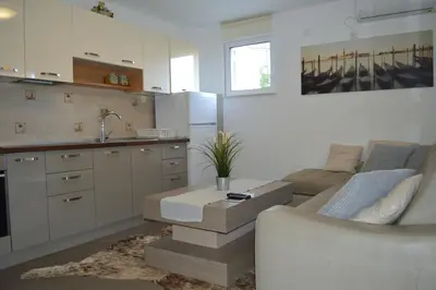 a kitchen with a couch and a table in a room at Vanessa Apartment in Budva