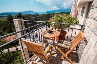 a balcony with two chairs and a table at Sunny Nest Apartments in Kotor
